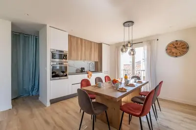 a kitchen with a table and chairs and a clock at BRP Cannes Center, Top floor Luxurious Apartment II, 4 bedrooms+3 bathrooms in Cannes