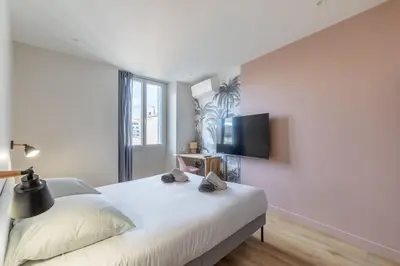 a bedroom with a white bed and a flat screen tv at BRP Cannes Center, Top floor Luxurious Apartment II, 4 bedrooms+3 bathrooms in Cannes