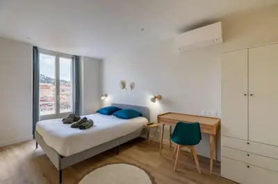 a bedroom with a bed and a desk and a window at BRP Cannes Center,Top floor Luxurious house,8 bed in Cannes