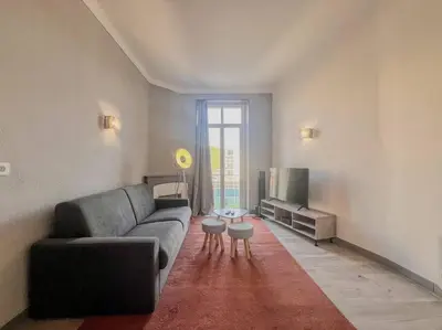 a living room with a couch and a tv at Cannes - Charming central apartment with balcony in Cannes