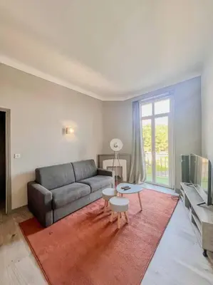 a living room with a couch and a table at Cannes - Charming central apartment with balcony in Cannes