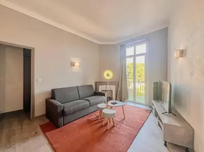 a living room with a couch and a television at Cannes - Charming central apartment with balcony in Cannes