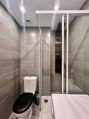 a small bathroom with a toilet and a shower at Cannes - Charming central apartment with balcony in Cannes