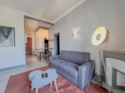 a living room with a couch and a table at Cannes - Charming central apartment with balcony in Cannes