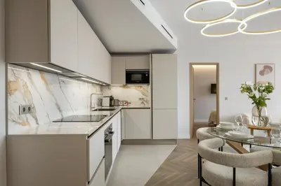 a kitchen with white cabinets and a dining table at Luxury Romantic Cannes 45 Croisette Two Bedrooms in Cannes
