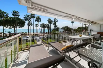 a balcony with chairs and a table and a view of the ocean at REF 1337 - Cannes Croisette - Sea view apartment for rent in Cannes