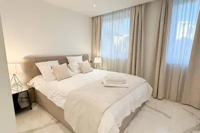 a white bedroom with a large bed and a window at REF 1337 - Cannes Croisette - Sea view apartment for rent in Cannes