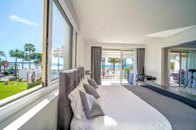 a bedroom with a large bed with a view of the ocean at REF 1337 - Cannes Croisette - Sea view apartment for rent in Cannes