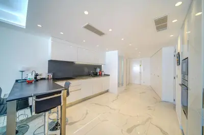 a kitchen with white cabinets and a black counter at REF 1337 - Cannes Croisette - Sea view apartment for rent in Cannes