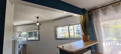 a room with a table and a window with a plant at Le Ptit Ecrin du Lerins in Cannes