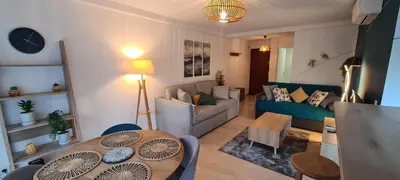 a living room with a couch and a table at Le Ptit Ecrin du Lerins in Cannes