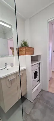 a bathroom with a sink and a washing machine at Le Ptit Ecrin du Lerins in Cannes
