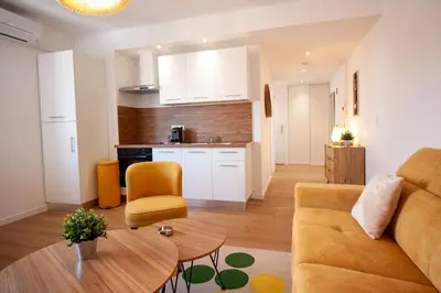 a living room with a couch and a table at Brand New Central Cannes Apt 2 min walk to Palais in Cannes
