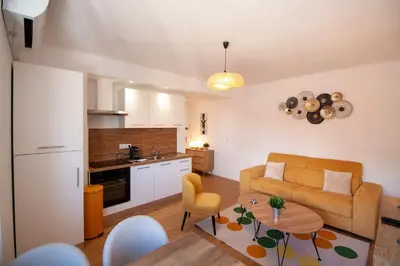 a living room with a couch and a table at Brand New Central Cannes Apt 2 min walk to Palais in Cannes