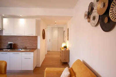 a kitchen and a living room with a couch at Brand New Central Cannes Apt 2 min walk to Palais in Cannes