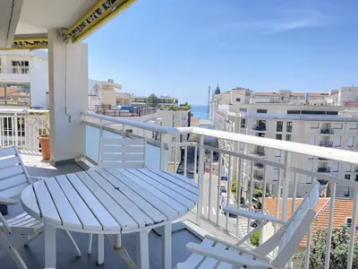 a table and chairs on a balcony with a view of the ocean at Cannes proche Croisette - Appartement 3 Pièces vue mer terrasse Helv7 in Cannes