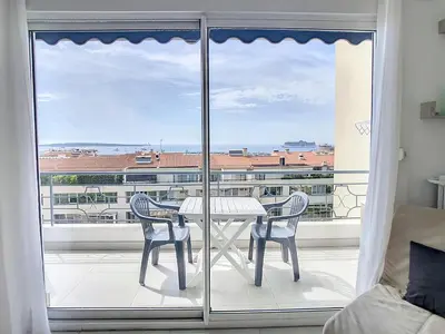a table and chairs on a balcony with a view at Lovely, modern studio with sea view 117 in Cannes