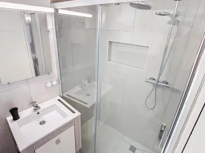 a white bathroom with a shower and a sink at Lovely, modern studio with sea view 117 in Cannes