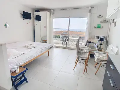 a hospital room with a bed and a table and chairs at Lovely, modern studio with sea view 117 in Cannes