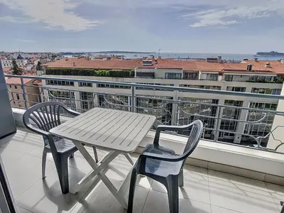 a wooden table and two chairs on a balcony at Lovely, modern studio with sea view 117 in Cannes