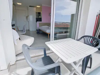 a white table and chairs in a room with a window at Lovely, modern studio with sea view 117 in Cannes