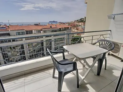 a table and chairs on a balcony with a view at Lovely, modern studio with sea view 117 in Cannes
