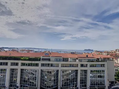 a large white building with a view of a city at Lovely, modern studio with sea view 117 in Cannes