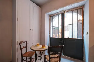 a small table and chairs in a room with a window at Charming studio In the heart of Cannes in Cannes