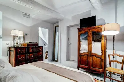 a bedroom with a wooden dresser with a television on it at Charming studio In the heart of Cannes in Cannes
