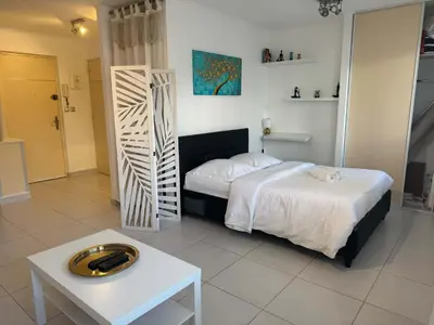 a bedroom with a white bed and a table and a bed sidx sidx sidx at B075-Studio agréable centre Cannes in Cannes