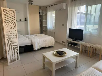 a living room with a bed and a television at B075-Studio agréable centre Cannes in Cannes