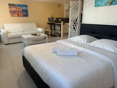 a bedroom with a large bed and a living room at B075-Studio agréable centre Cannes in Cannes