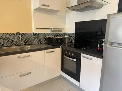 a kitchen with white cabinets and a sink at B075-Studio agréable centre Cannes in Cannes