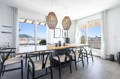 a dining room with a large wooden table and chairs at Outstanding Rooftop Cannes 4 bed Apt Sea Views in Cannes