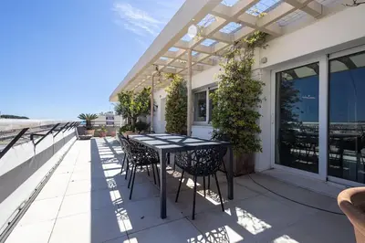 a patio with a table and chairs on a balcony at Outstanding Rooftop Cannes 4 bed Apt Sea Views in Cannes