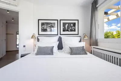 a white bedroom with a large white bed with two pillows at Outstanding Rooftop Cannes 4 bed Apt Sea Views in Cannes