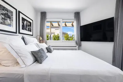a white bedroom with a large bed and a window at Outstanding Rooftop Cannes 4 bed Apt Sea Views in Cannes