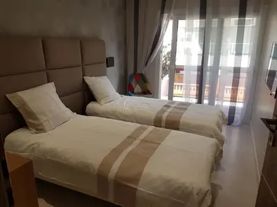 two beds sitting in a room with a window at Cannes appartement 3 chambres - 8D in Cannes