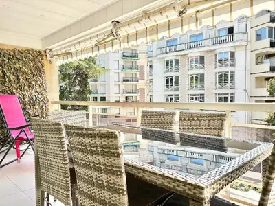 a balcony with chairs and a table and a building at Cannes appartement 3 chambres - 8D in Cannes