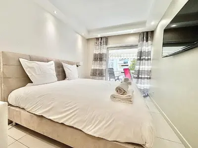 a bedroom with a bed with white sheets and a window at Cannes appartement 3 chambres - 8D in Cannes