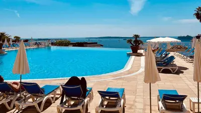 a large swimming pool with chairs and umbrellas at CANNES Appartement - terrasse, jardin prive, parking, piscine, climatisation in Cannes