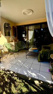 a living room with a couch and chairs and a table at CANNES Appartement - terrasse, jardin prive, parking, piscine, climatisation in Cannes
