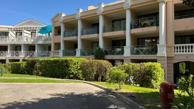 a large building with bushes in front of it at CANNES Appartement - terrasse, jardin prive, parking, piscine, climatisation in Cannes