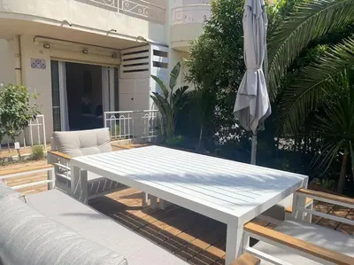 a white table and an umbrella on a patio at Cannes appartement 1 chambre - Victoriam in Cannes