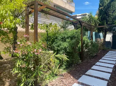 a garden with a wooden pergola and some plants at Cannes appartement 1 chambre - Victoriam in Cannes