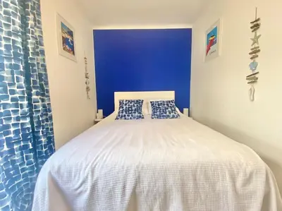 a bedroom with a white bed with a blue wall at Cannes appartement 1 chambre - Victoriam in Cannes