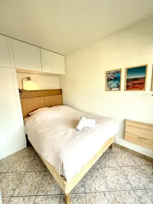 a bedroom with a large bed with white sheets at T2 avec terrasse, Gare Cannes & Croisette à pied in Cannes