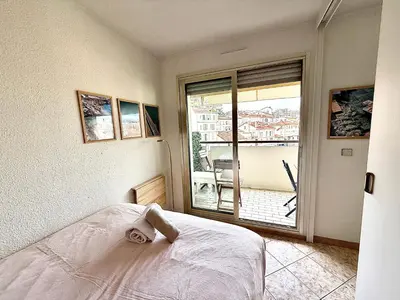 a bedroom with a bed and a large window at T2 avec terrasse, Gare Cannes & Croisette à pied in Cannes