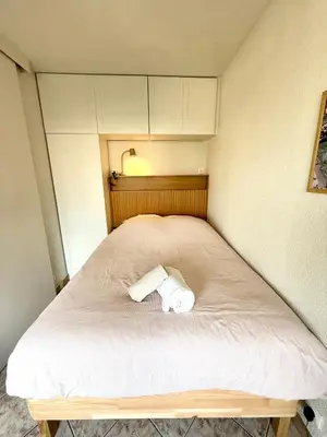 a small bed with a roll of toilet paper on it at T2 avec terrasse, Gare Cannes & Croisette à pied in Cannes