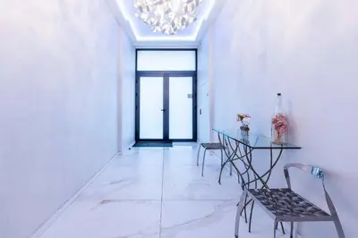 a dining room with a table and chairs and a chandelier at Bliss Triplex - Hyper Centre - Sauna - BBQ - Jacuzzi - LRACANNES in Cannes
